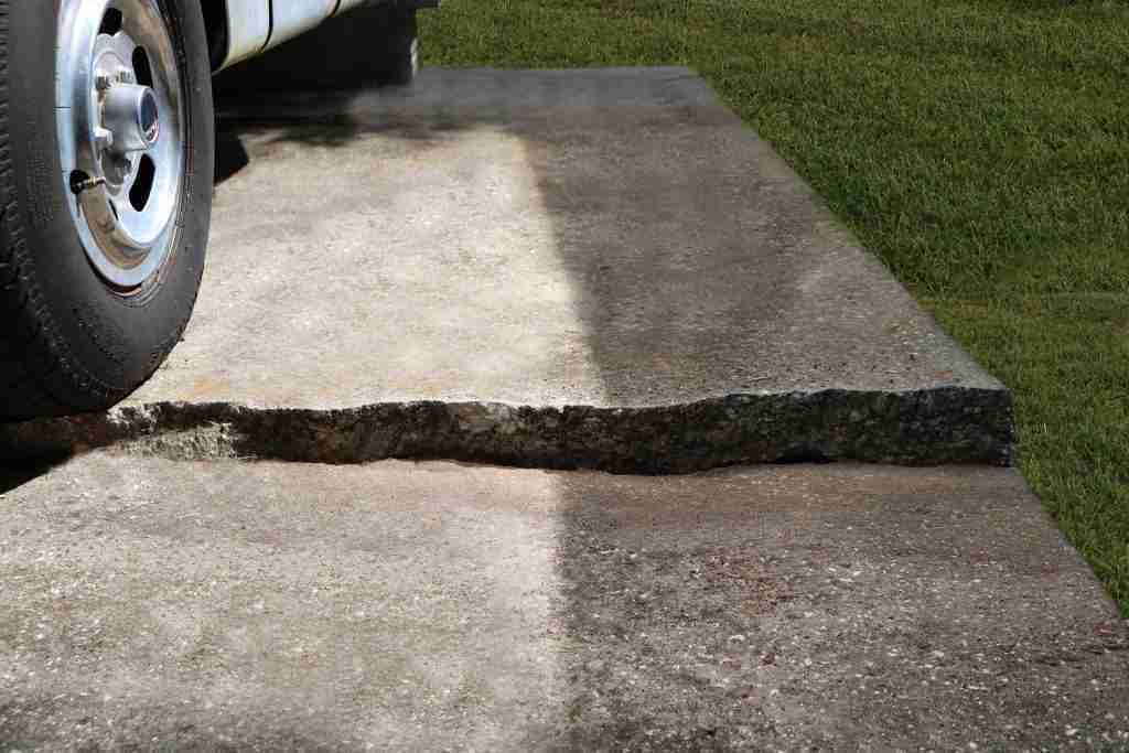 Sunken driveway slab with uneven concrete at a residential driveway